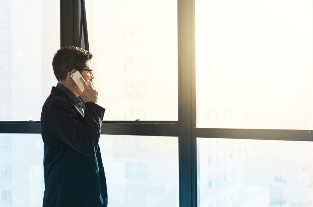 Imagem de um empresário falando ao telefone, ilustrando uma dúvida muito comum no Brasil: se vale a pena financiar uma franquia?