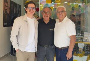 Na imagem, está o consultor financeiro da 4TE Group e os dois empresários que abriram uma nova franquia por meio da linha de crédito para franquias da 4TE Group. Nessa imagem, eles estão em frente à loja, no dia inauguração. Eles estão de pé, sorrindo para tirar a foto.