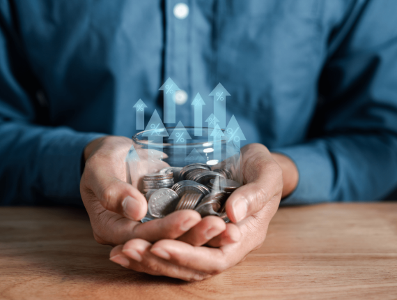Imagem de um homem segurando um pote com moedas, ilustrando um empresário que precisa de capital de giro para o sei negócio.
